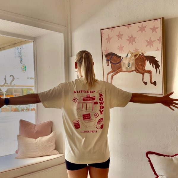 Person showing T-shirt design in sunny room
