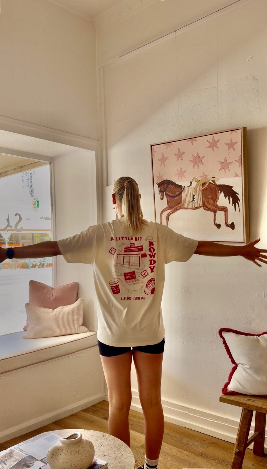 Person showing T-shirt design in sunny room